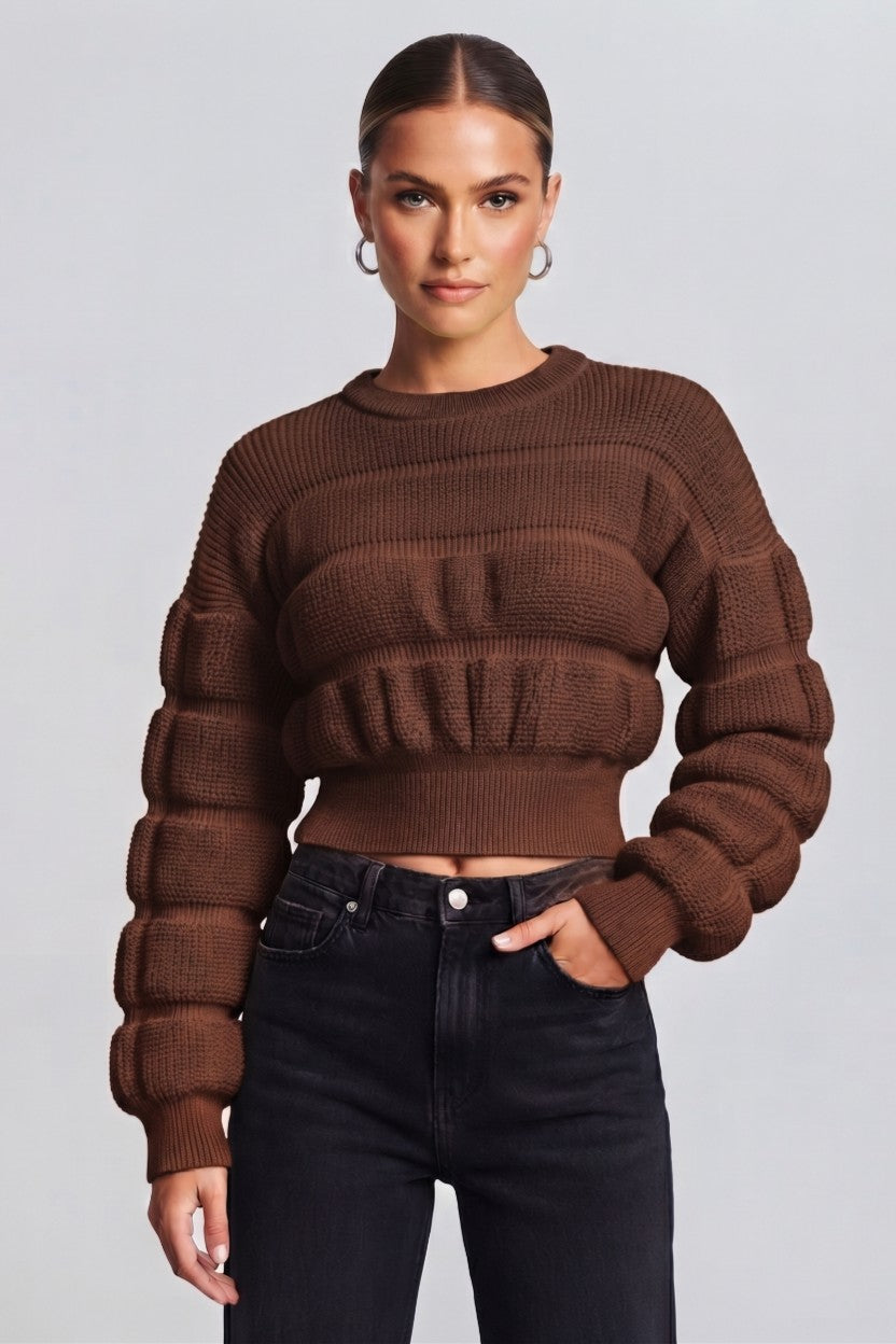 woman wearing a brown, textured knit sweater.