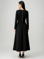 Woman wearing a black long-sleeve dress on a white background