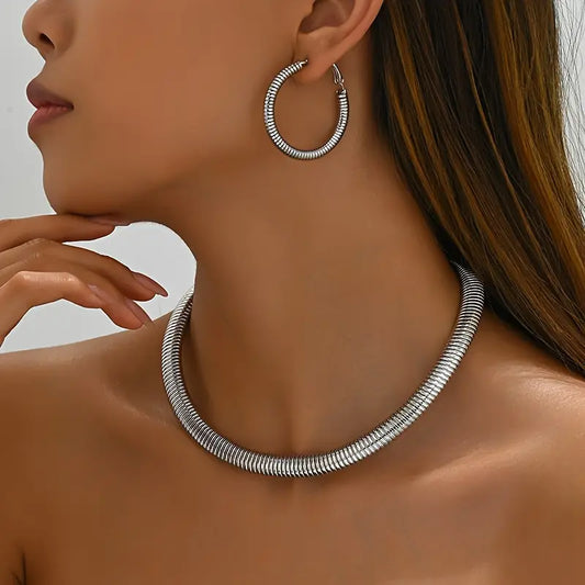 Silver hoop earring and necklace on a model against a neutral background