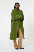 Person wearing a green coat on a white background
