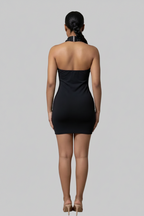 Woman wearing a black strapless dress against a plain background