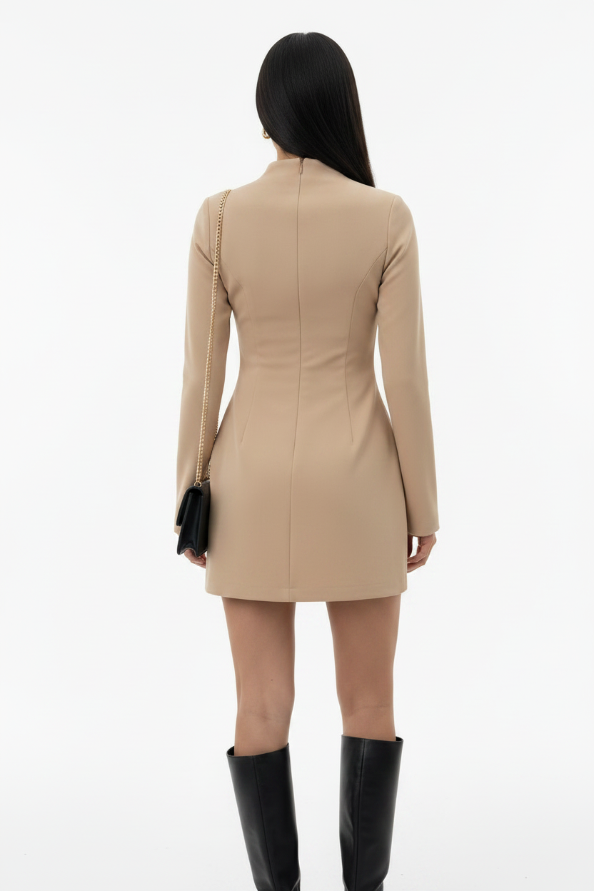 Person wearing a beige dress with long sleeves on a white background