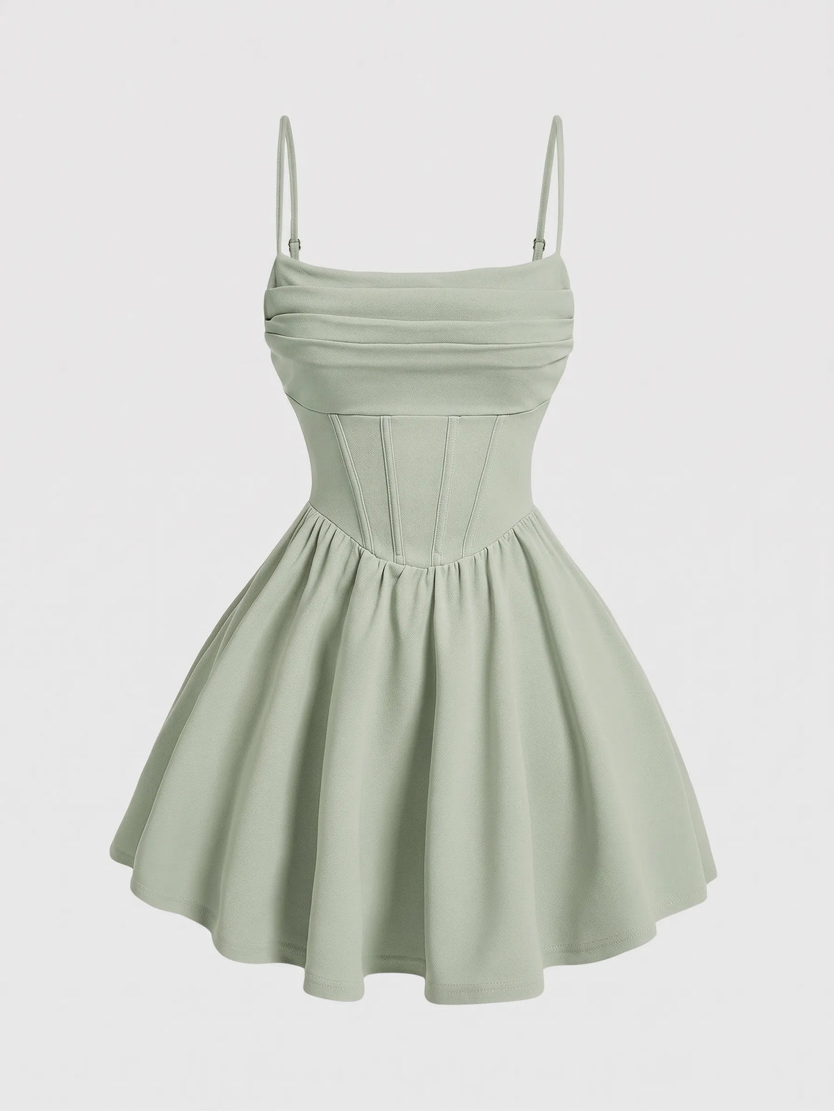 A light sage green mini dress with thin spaghetti straps, a ruched sweetheart bodice, and a flared skirt, shown against a plain light gray background.