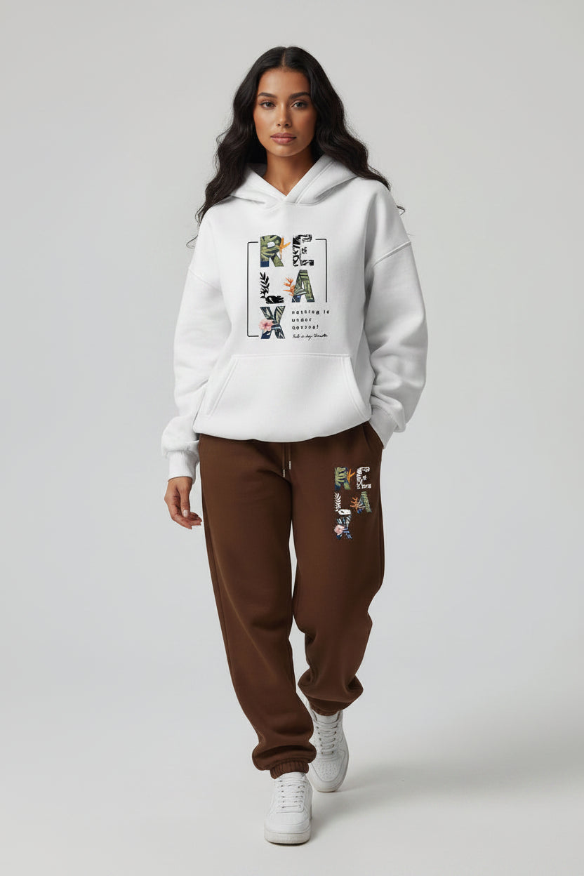 Woman wearing a white hoodie and brown sweatpants with 'RELAX' text, holding a coffee cup on a gray background