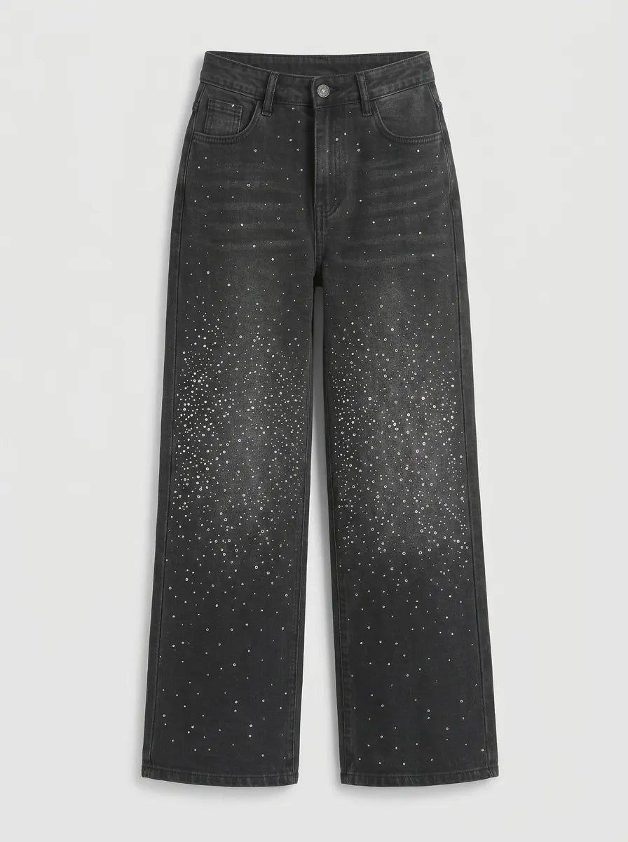 a pair of high-waisted, wide-leg jeans is crafted from a dark washed-black or washed-charcoal denim completely covered in a sparkling, all-over pattern of tiny silver rhinestones and crystal studs that scatter densely down the legs. 