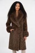 Woman wearing a leopard print coat with fur trim on a white background