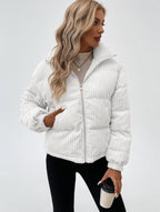 Woman wearing a white corduroy jacket on a plain background