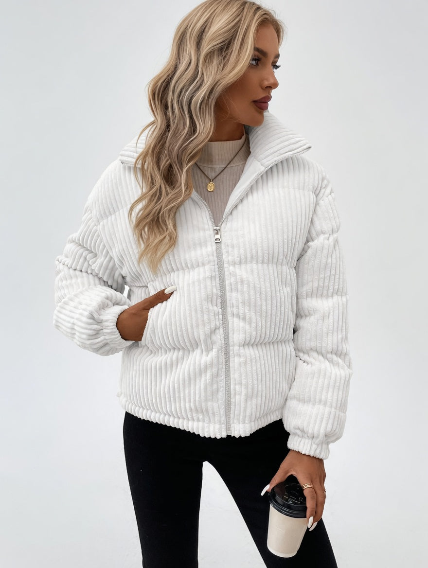 Woman wearing a white corduroy jacket on a plain background