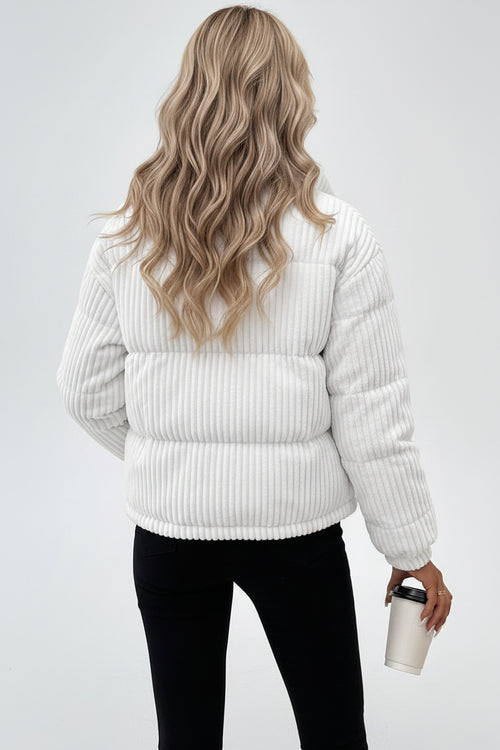 Woman wearing a white corduroy jacket on a plain background