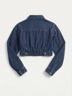 This is a deep indigo blue denim jacket features an ultra-cropped silhouette with long sleeves, tailored shoulder seams, and classic buttoned cuffs. It includes a traditional point collar and a full front placket detailed with smooth, metallic silver shank buttons.