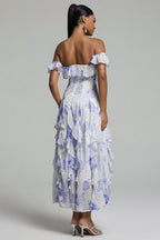 Woman wearing a floral off-shoulder dress against a gray background