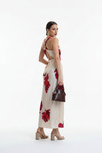 Woman wearing a white dress with red floral patterns on a white background