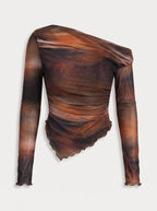 a long-sleeved, one-shoulder top is crafted from a sheer, lightweight mesh fabric featuring an abstract, smoky watercolor print in rich tones of warm rust orange, deep brown, and muted charcoal. The fitted, asymmetrical design features soft all-over ruching that contours the body, complemented by a sleek one-shoulder neckline and a uniquely curved, lettuce-edge hemline