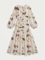 long midi dress crafted from a sheer, flowing fabric featuring an abstract, watercolor-inspired floral print in muted tones of cream, muted purple, sage, and warm amber. 