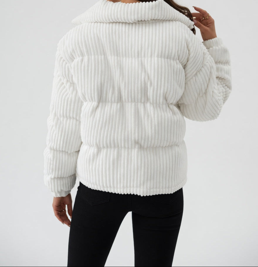 Woman wearing a white ribbed knit puffer jacket on a light gray background