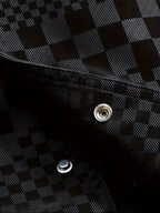 Close-up of a black and white checkered fabric with metal buttons.
