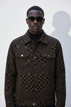 Man wearing a checkered jacket and sunglasses against a white background