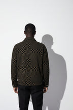 Person wearing a patterned jacket against a white background