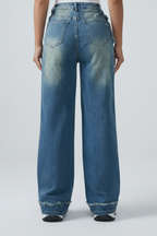 Blue jeans worn by a person on a white background