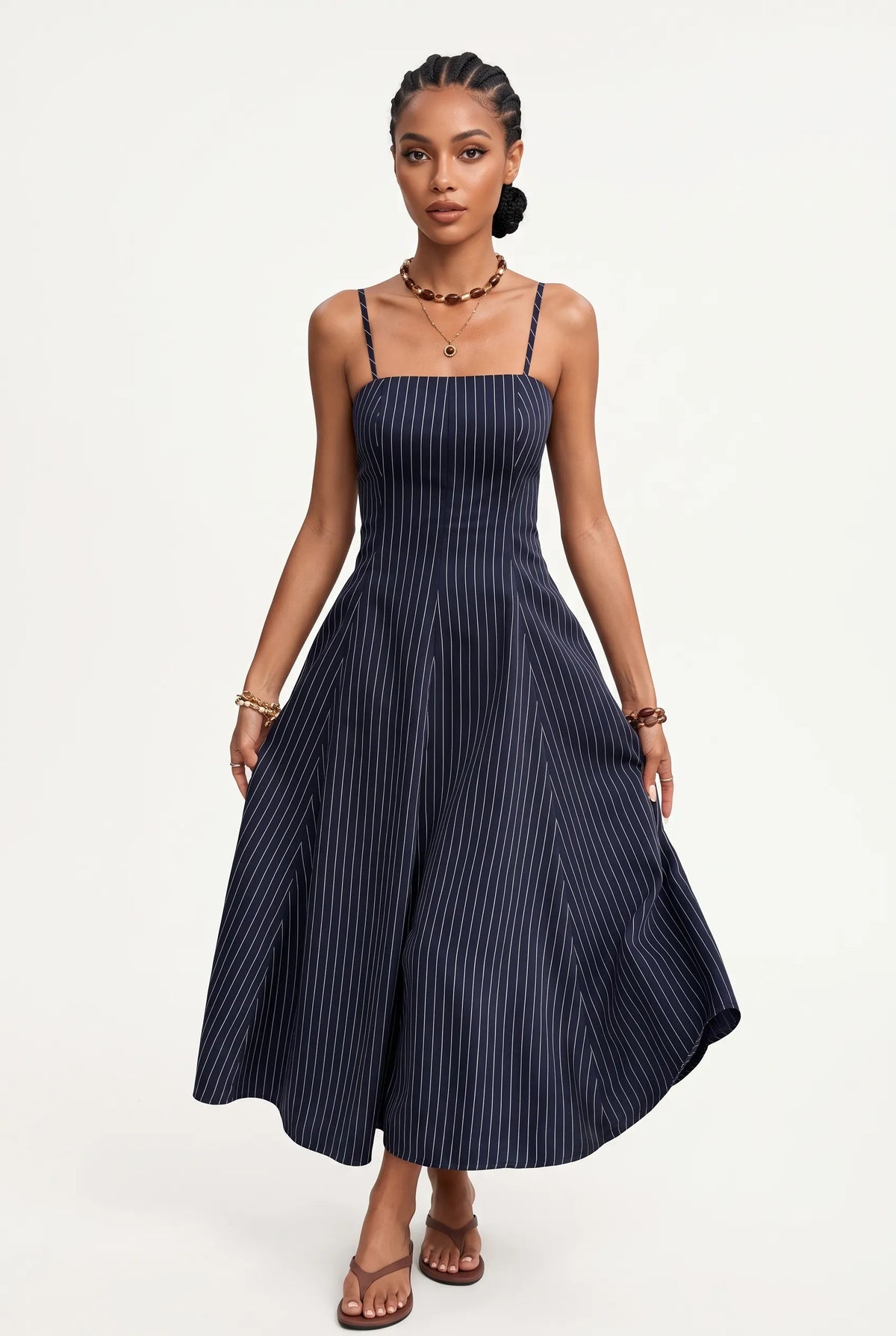 A woman modeling a navy blue midi dress with thin vertical pinstripes, shown from a three-quarters back view against a plain white studio background.