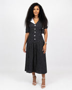 Woman wearing a black polka dot dress on a white background