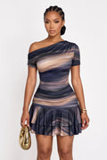 A woman modeling a one-shoulder ruched mini dress with a blue, beige, and brown abstract swirl pattern, holding a gold clutch against a plain white background.