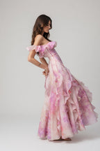 Woman wearing a pink floral off-shoulder gown on a white background