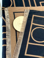 Close-up of a fabric with geometric patterns and a wooden circular object on a blue and beige background.