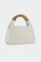 White handbag with a wooden handle on a light gray background