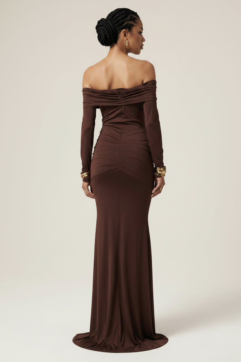 Woman wearing a brown off-shoulder gown against a beige background