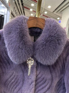 Purple fur coat with a decorative brooch on a hanger in a store setting