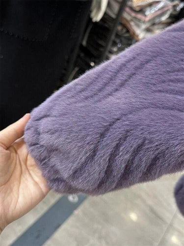 Close-up of a purple textured sleeve held by a hand with a blurred background