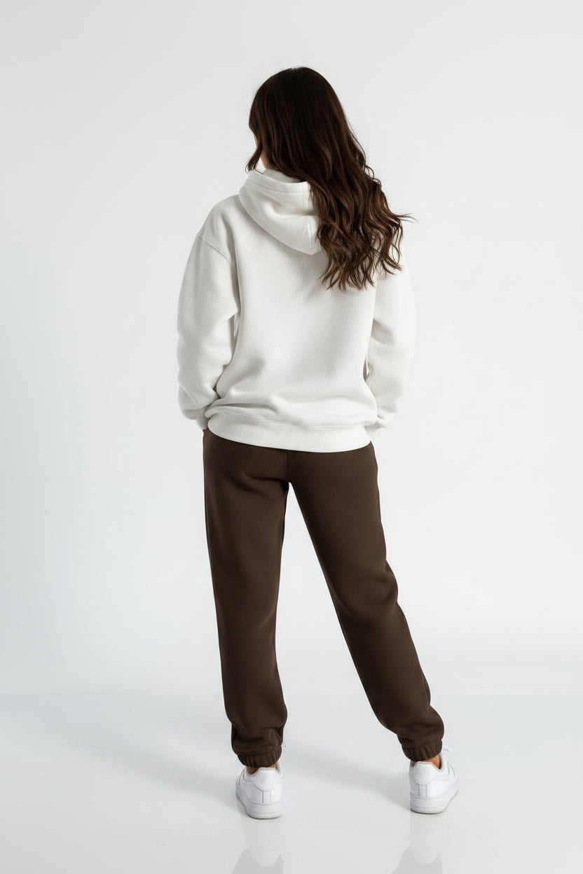 Person wearing a white hoodie and brown pants on a white background
