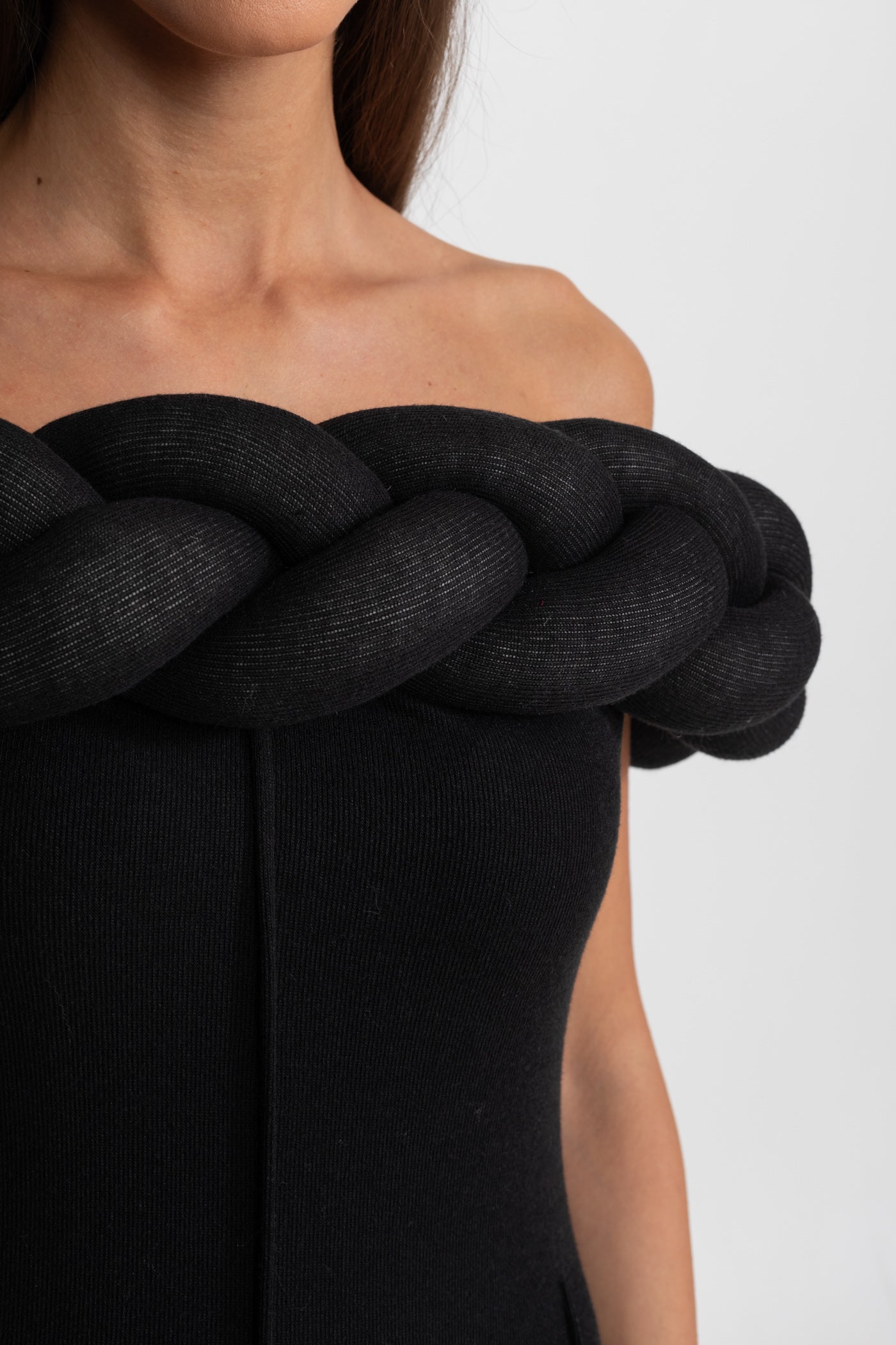 Black off-shoulder dress with a large knot detail on a white background