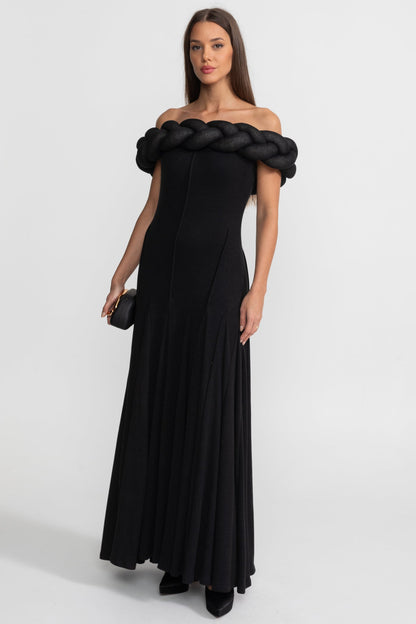 Woman wearing a black off-shoulder evening gown on a white background