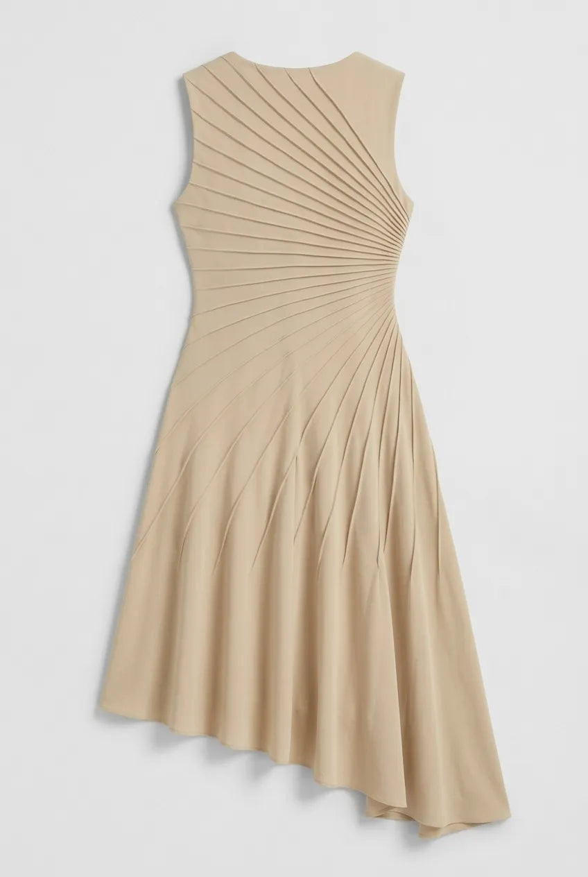 This sleeveless, beige midi dress features a crew neckline and a sophisticated sunray pin-tuck design that radiates outward across the fitted bodice. Crafted from a fluid, medium-weight fabric, the dress forms structural pleated lines that extend downward through an A-line silhouette, culminating in a dramatic asymmetrical high-low hemline that flows gracefully around the legs.