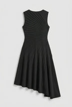 This sleeveless, black midi dress features a crew neckline and a sophisticated sunray pin-tuck design that radiates outward across the fitted bodice. Crafted from a fluid, medium-weight fabric, the dress forms structural pleated lines that extend downward through an A-line silhouette, culminating in a dramatic asymmetrical high-low hemline that flows gracefully around the legs.