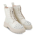 White combat boots with studded details on a white background