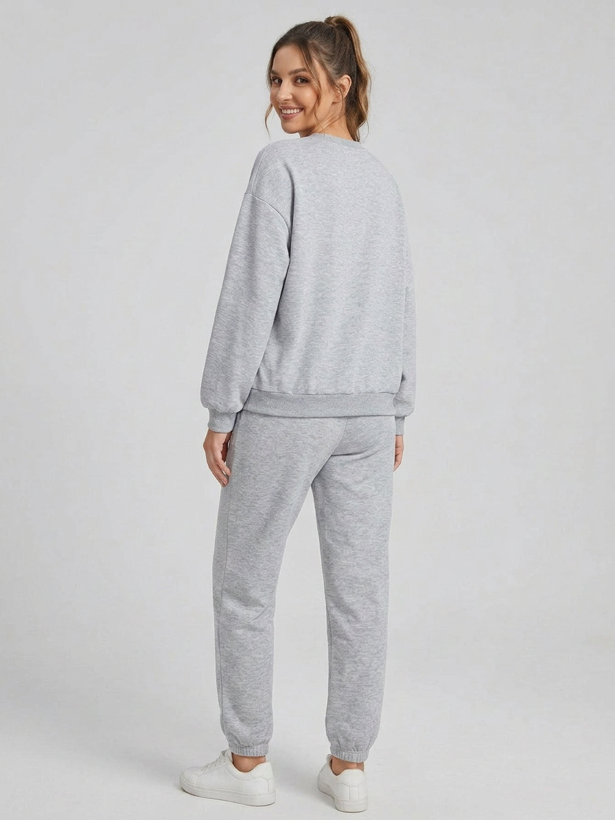 Woman wearing a gray sweatshirt and pants set on a white background