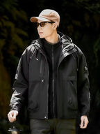 Person wearing a black jacket and beige cap in a dark forest setting