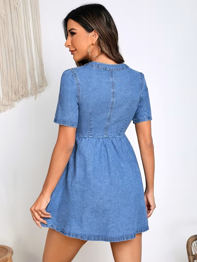 Woman wearing a blue denim dress against a white background