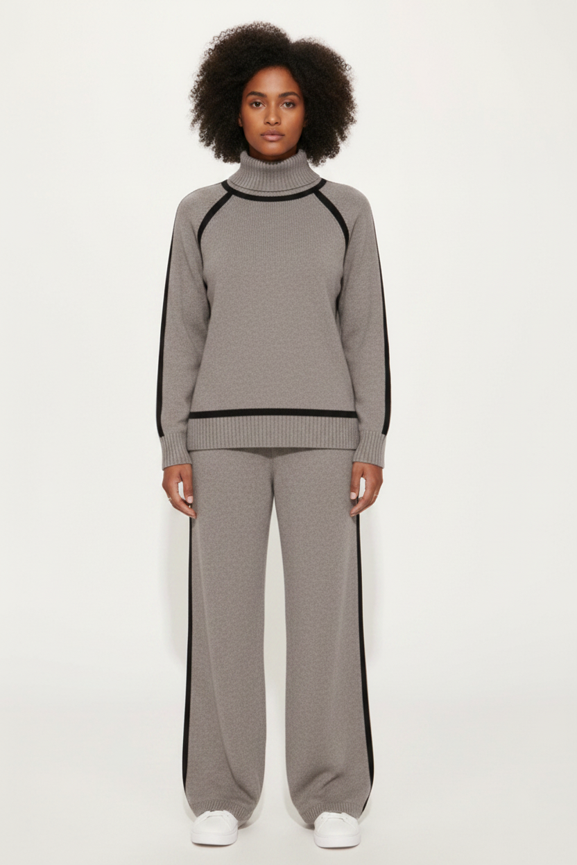 Person wearing a gray tracksuit with black trim on a white background