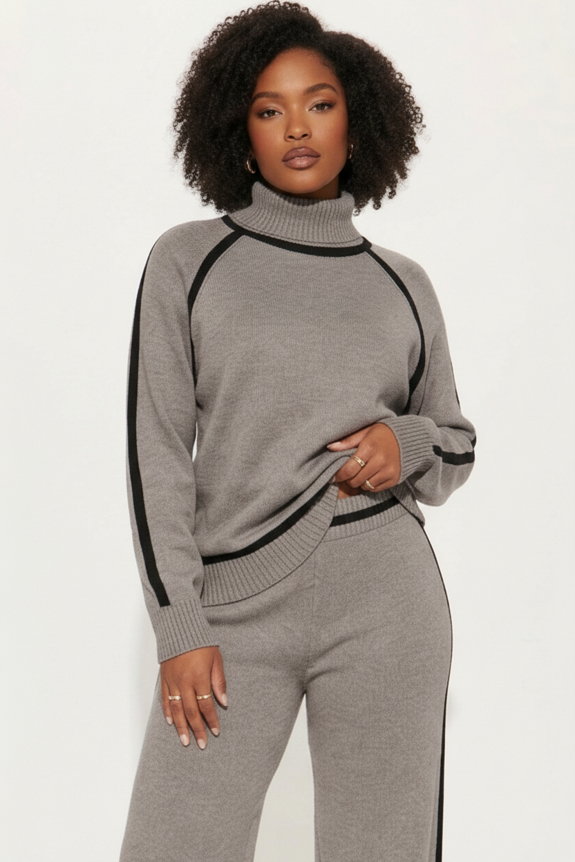Woman wearing a gray tracksuit with black stripes on a white background
