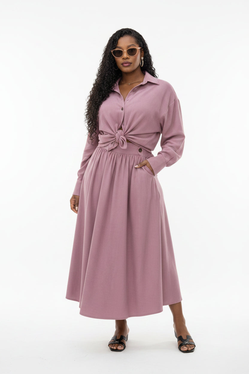 Woman wearing a pink outfit standing in a whitebackgroundl.