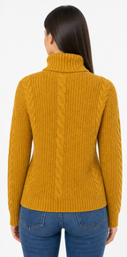 Woman wearing a mustard yellow cable knit sweater and blue jeans on a white background