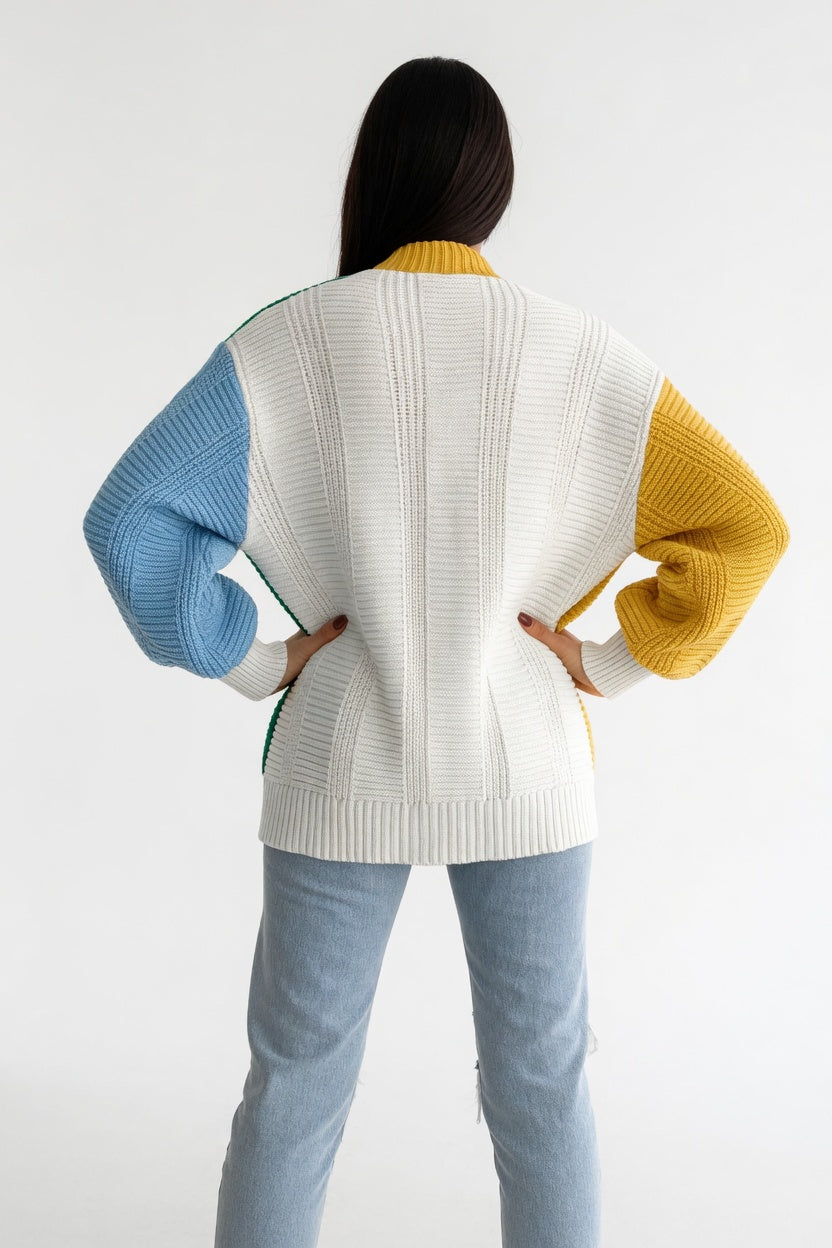 Person wearing a colorful sweater with blue, yellow, and white sleeves on a white background