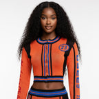 Woman wearing an orange and blue sweater with number 23 on a white background
